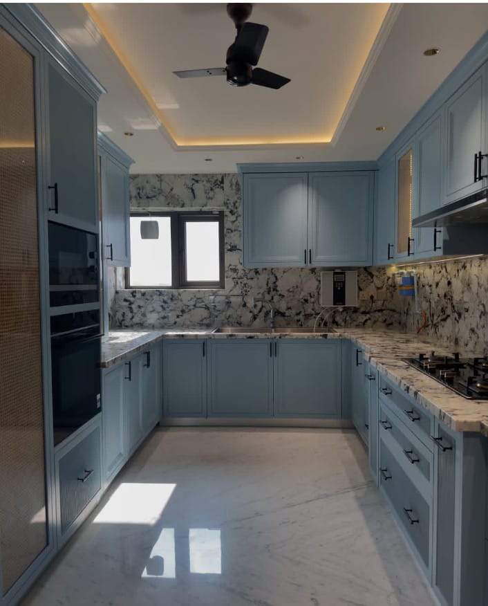 Modular kitchen with marble island by JAR Interio